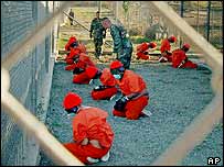 Guantnamofanger p grdtur ifrt gasmaske og orange   
sikkerhedsdragter